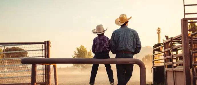 Father and son on a ranch in cowboy hats