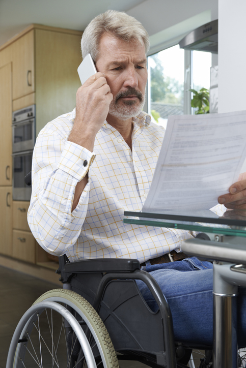 Man in wheel chair discussing social security benefits over the phone