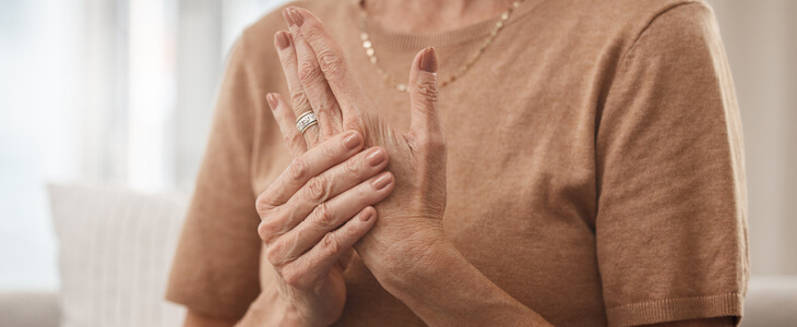 elderly woman holding her hand because of carpal tunnel syndrome
