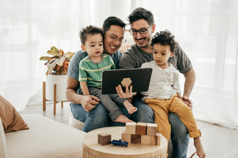 same-sex parents and kids looking at tablet