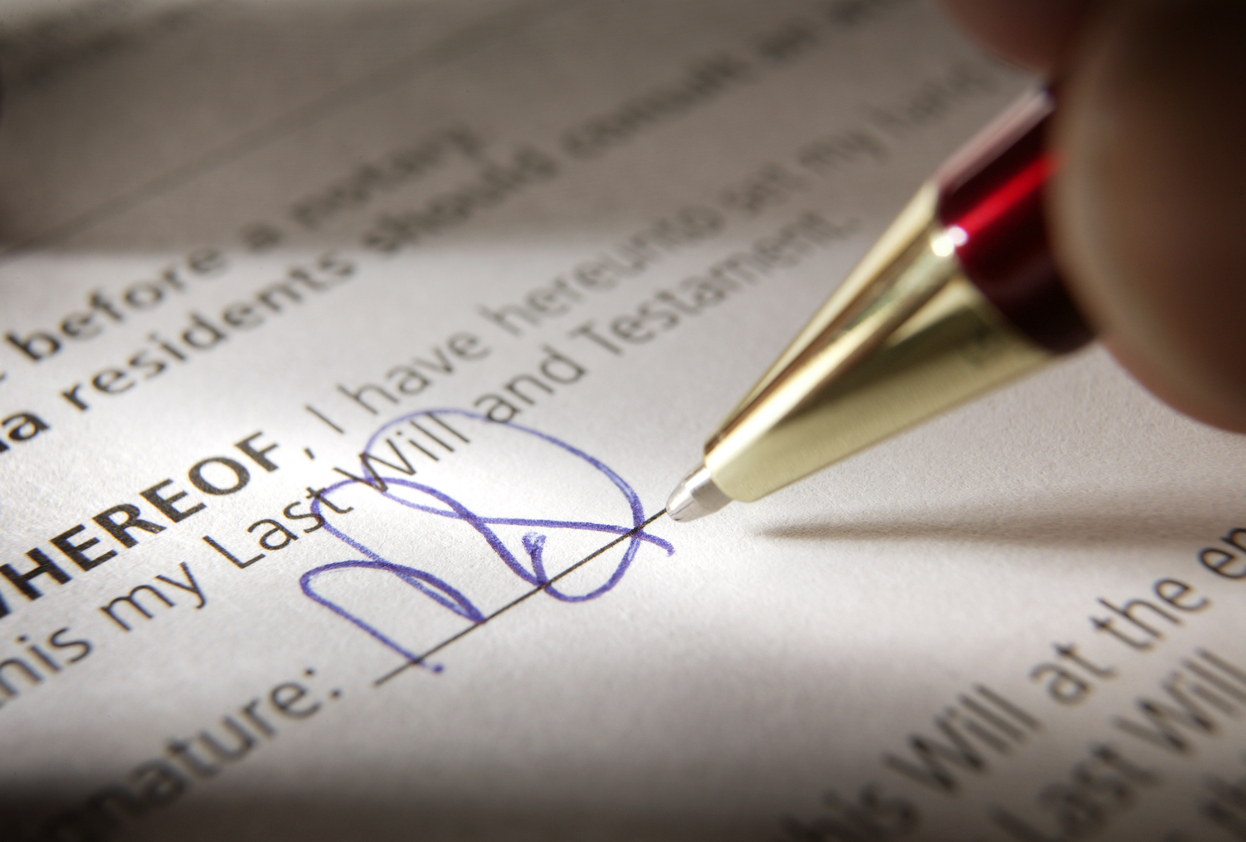 Close-up shot of a man signing a credit shelter trust