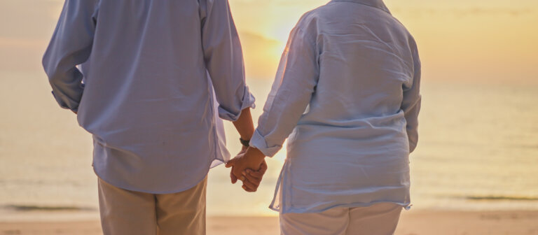 Senior couple holding hands by the beach