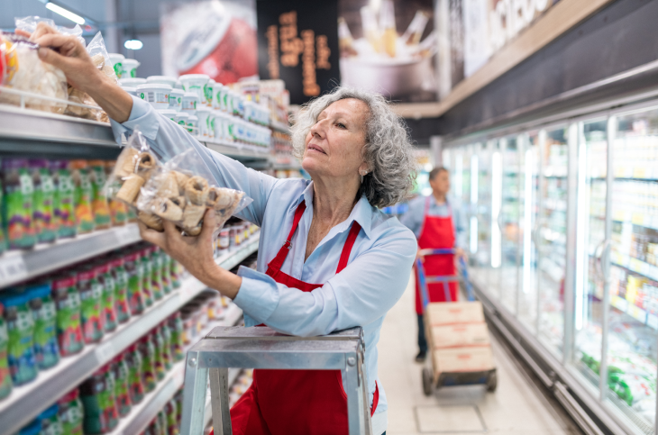 elderly person working at a grocery store part time