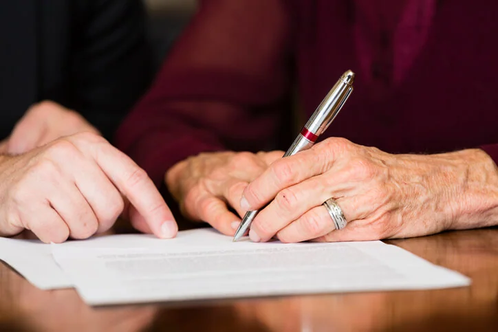 Older woman signing estate planning document