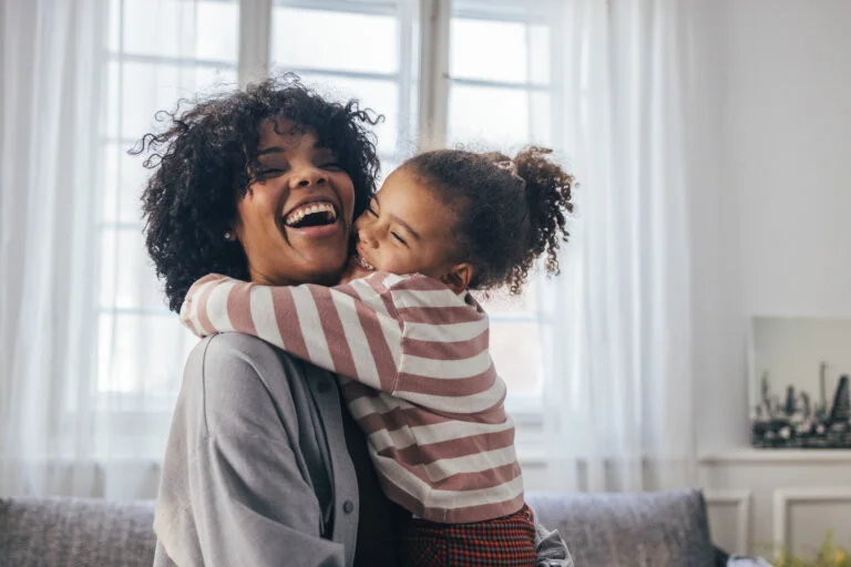 single parent smiling with her child in fort worth texas thinking about hiring an estate planning lawyer