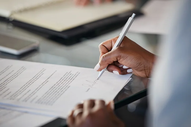 Woman signing a piece of paper